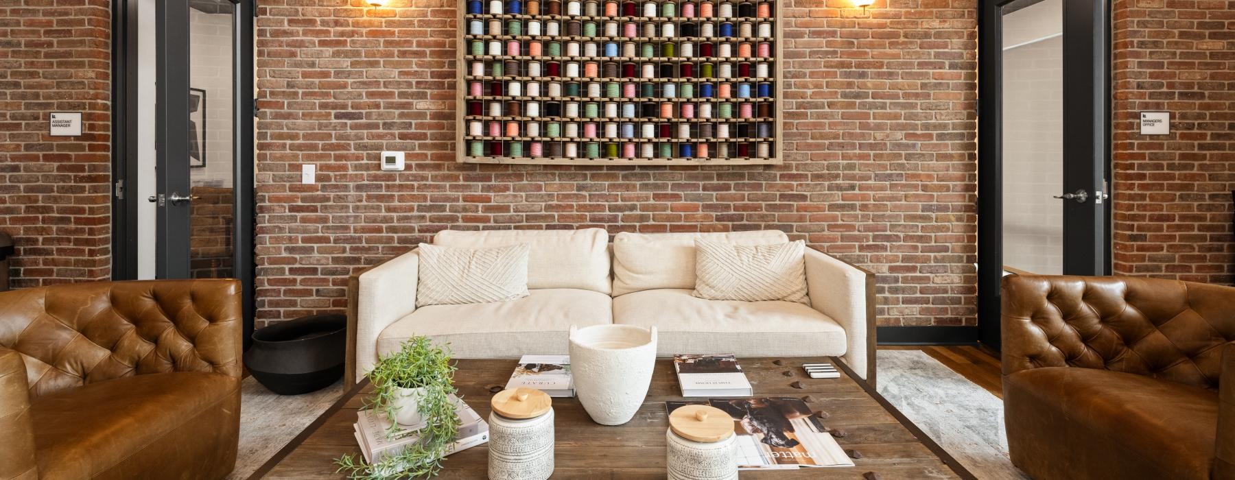 Resident lounge with sofa and chairs at The Grace at Tryon apartments on N Tryon Street in Charlotte, NC