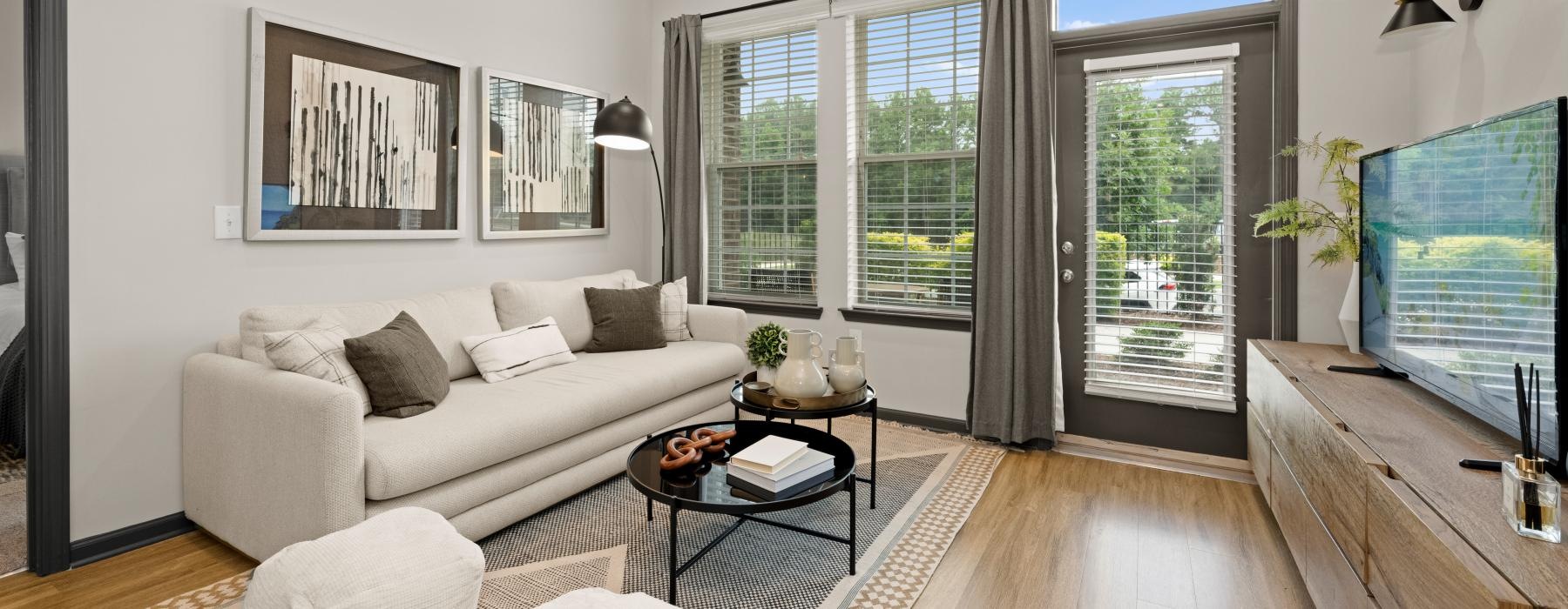 Modern living room with large window in a one-bedroom Charlotte apartment at The Grace at Tryon